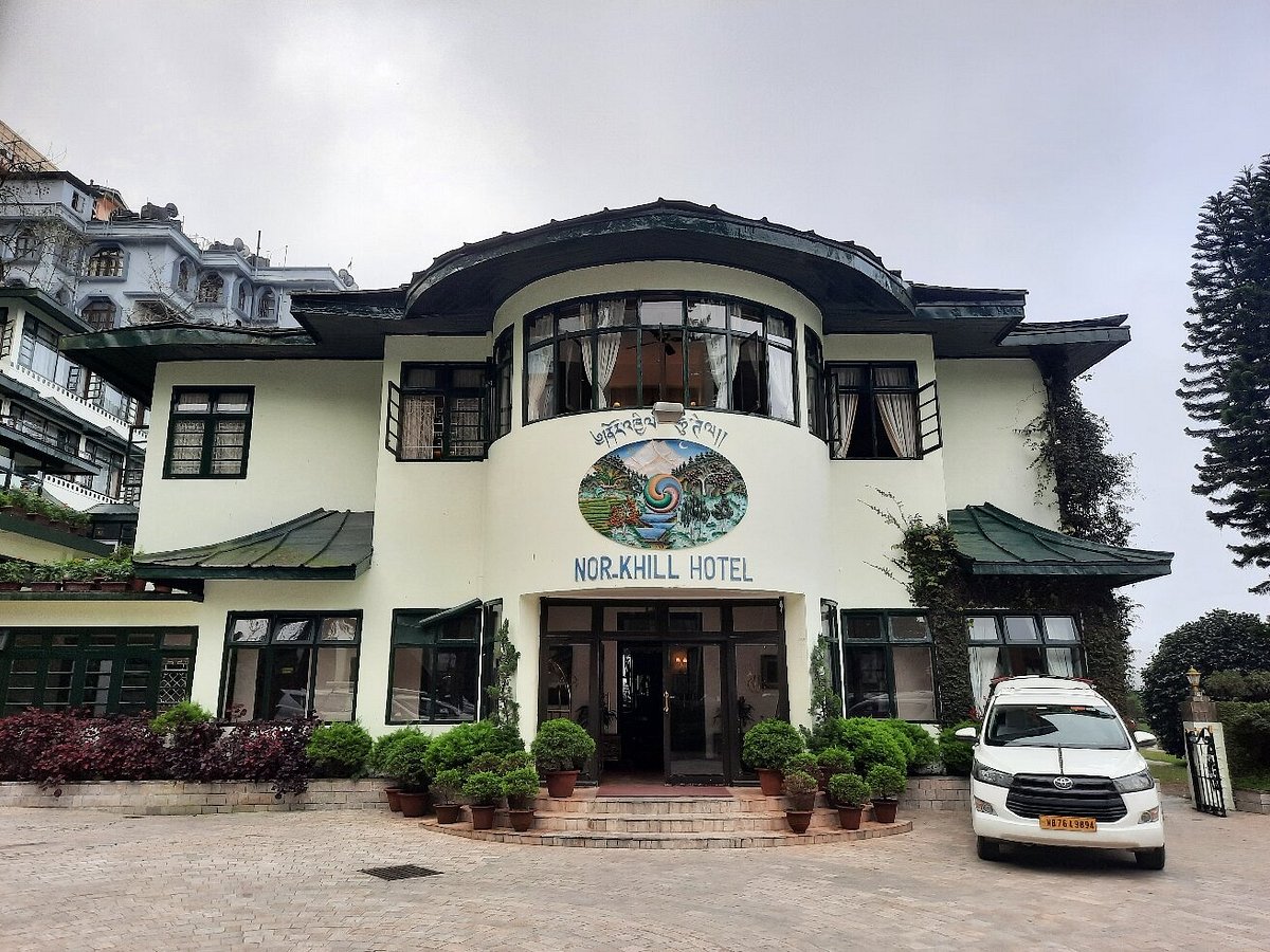 Description: A premier 4-star heritage hotel originally built as a royal guesthouse for the Chogyal of Sikkim. It features "Old World" charm with Burmese teak flooring, crackling fireplaces, and traditional Sikkimese folk art. Located in the heart of Gangtok, it offers a high-end spa, a quiet library, and rooms with sweeping views of the Himalayas and the Teesta Valley.