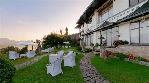 Description: Set in a prime 4-star location right next to the ancient Pemayangtse Monastery, this heritage property is spread across 8 acres of virgin forest. Every room offers a panoramic, unobstructed view of the Kanchenjunga range. The hotel provides a sophisticated retreat with colonial-style interiors, an oak-paneled bar, and a dining room serving gourmet mountain cuisine.
