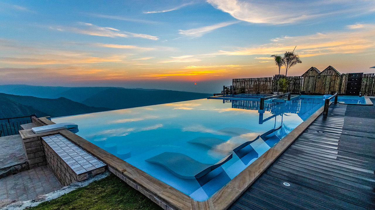 Description: Perched on the edge of a cliff overlooking the exotic Seven Sisters Falls and the plains of Bangladesh, the 5-star Luxury Pavilions offer an unparalleled "misty" experience. These villas feature private balconies, open-to-sky rain showers, and localized heating systems. After a day of subterranean exploration in the Mawsmai or Arwah caves, you can unwind at the "SoRA" spa or enjoy a private bonfire at the resort’s infinity pool deck, which is widely considered the best sunset viewpoint in Cherrapunjee.