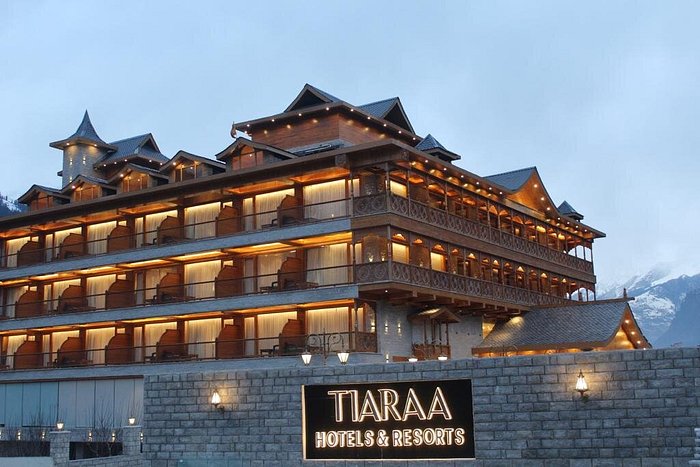 Description: A premier 5-star mountain retreat that serves as the perfect sanctuary for the first half of your honeymoon. The resort features centrally heated luxury suites with expansive private balconies offering uninterrupted views of the Hampta Pass and the Beas River. The property is known for its "Royal Honeymoon" service, which includes specialized room decor, a heated indoor pool, and a high-end spa. The in-house restaurant, The Grand Pavilion, offers a refined dining experience with a focus on both local Himachali delicacies and global gourmet cuisine.