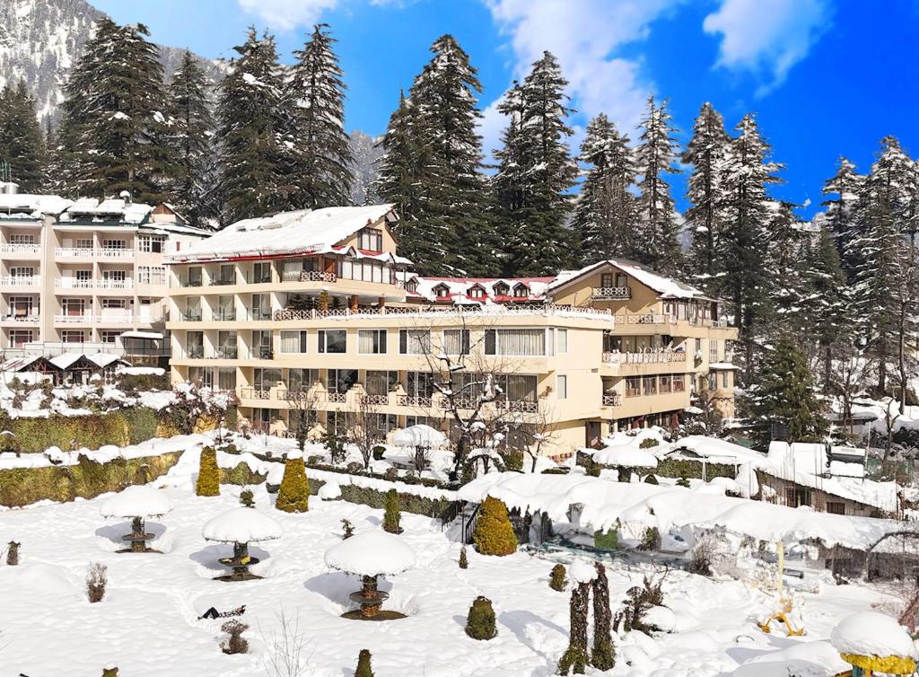 Description: Situated in the peaceful Log Huts area, this 4-star resort is a favorite for trekkers and mountain enthusiasts. It offers easy access to the trails leading toward Old Manali and the Solang Valley. The rooms are designed with local wood finishes and offer panoramic views of the snow-clad peaks. After a day of paragliding or hiking, you can relax at their rooftop terrace or the chic bar designed for social interaction among travelers.