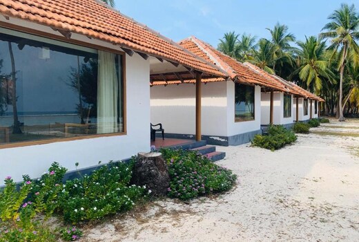 Description: A premium beachfront resort located on the crystal-clear lagoon side of Agatti Island. It features independent air-conditioned cottages constructed with local materials and modern interiors. The property offers a private beach area, a multi-cuisine restaurant specializing in fresh seafood, and a dedicated water sports desk for immediate access to snorkeling and scuba diving.