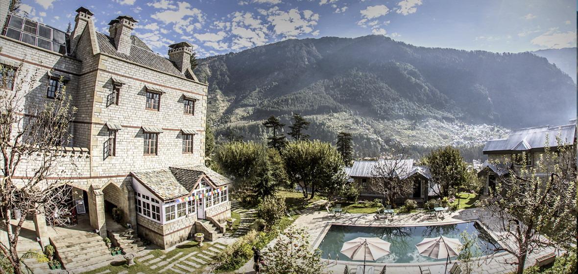 A stunning 4-star boutique resort built like a Victorian Gothic castle. It features an outdoor pool, rooms with stone fireplaces, and lush gardens overlooking the snow-capped peaks.